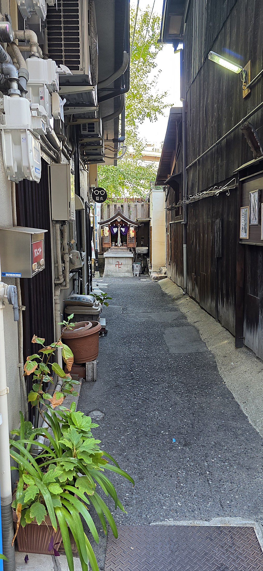 Enge Gasse mit kleinem Schrein in japanischer Stadt